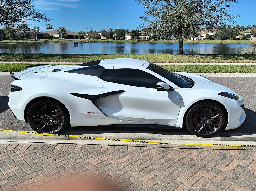 White Chevrolet Corvette C8 detailed to a mirror finish by a lake