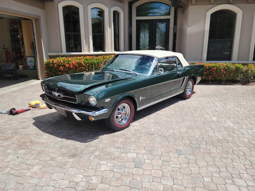 Classic Ford Mustang convertible being detailed with a polisher